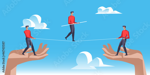 Uomo che cerca di stare in equilibrio sulla fune sostenuta da altri due uomini