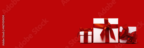 set of tree assorted red and white gift boxes on red background. different size. Merry Christmas and Happy New Year gift shopping and sale concept. St Valentines Day or birthday gift. Minimal edgeless