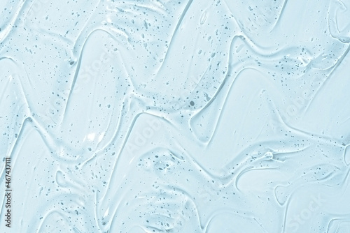 Cosmetic gel or beauty jelly serum texture background. Transparent skin care collagen product backdrop. Antibacterial sanitizer or liquid water moisture toner smudged smear close up photo
