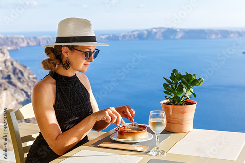 Valokuvatapetti Young woman has dinner in a restaurant overlooking the sea