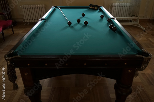  billiard balls on a table with green mat. The balls are placed to start the game. photo