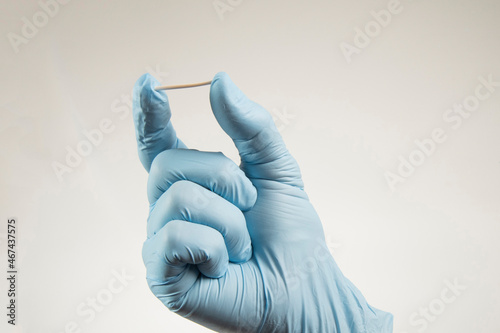 hand in rubber gloves holding a hormonal implant.