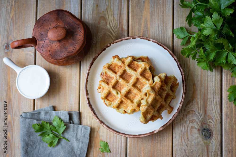 A hearty snack for lunch: thick potato waffles on a white plate. Top view A hearty snack for lunch: thick potato waffles on a white plate. Top view