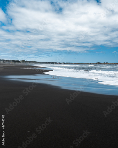 Vertical photo of a flock of birds on pichilemu's infiernillo beach on a cloudy day.