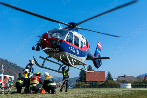 Fotografering Firefighters supporting a Police Helicopter to transport equipment to a mountain