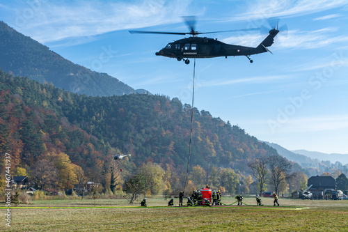 Firefighters fill a water Bucket of an Austrian Armed Forces S-70 