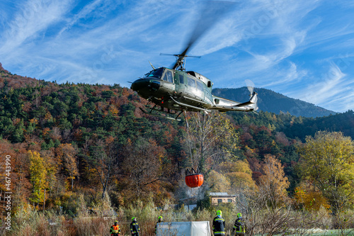 An Austrian Armed Foreces Helicopter immeres a water Bucket to fight a forest fire from the Air