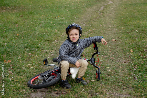 Portrait of smiling boy in a helmet with a bicycle in the park