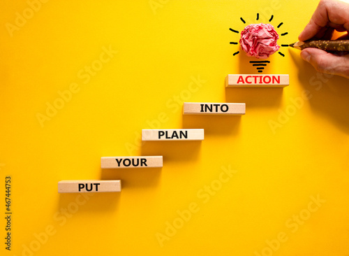 Put your plan into action symbol. Wooden blocks with words Put your plan into action. Beautiful yellow background, copy space. Businessman hand, light bulb. Business, plan into action concept.