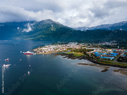 Aerial view of hornopiren with its snow-capped mountains and ships on its coast at sunrise on a winter day.