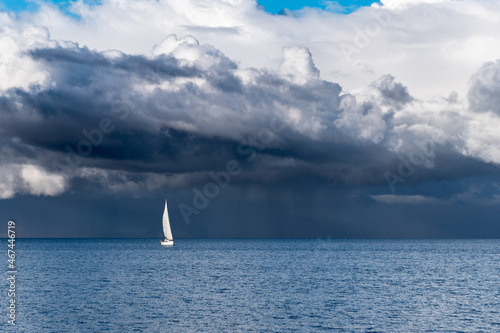 Panoramic view of a sailboat with a background full of storm clouds on lake llanquihue in frutillar, Chile.
