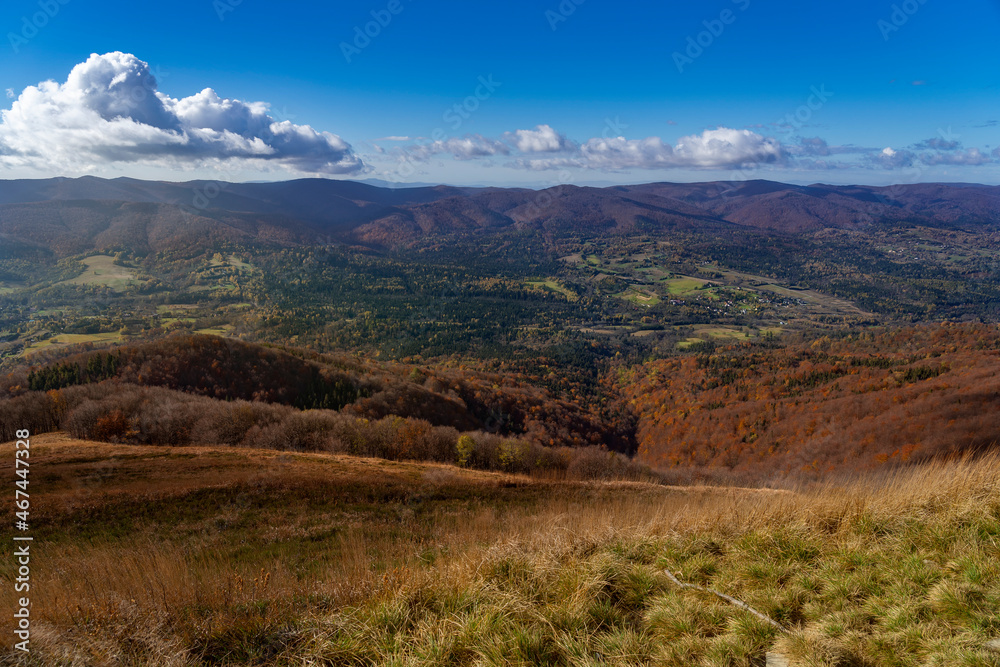 Amazing colours of autumn in Bieszczady mountains (Podkarpackie, Poland). Hiking Trail from Smerek to Polonina Wetlinska with view of local village. 