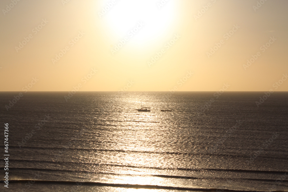 Vessel crossing the sunset light in Jericoacoara.