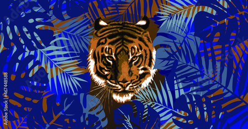 A tiger looks out of the jungle. Leaves, branches, grass, the muzzle of a predatory animal. Sign, symbol of 2022. 