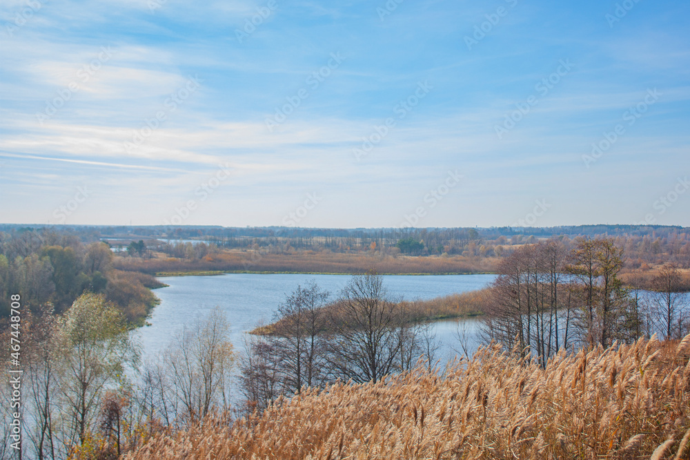 Autumn view of the blue river and yellow vegetation. Autumn landscape in bright sunny. Blue sky.