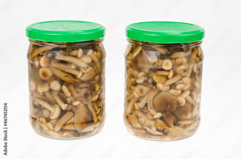 Pickled wild mushrooms in glass jar. Homemade preparations. Studio Photo