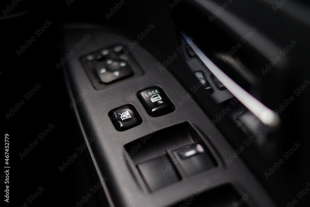 close-up photo of window and mirror controls on a car