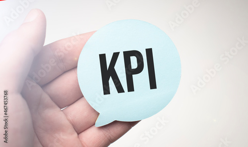 Businessman holding speech buble paper with a message KPI