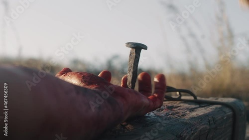 Anonymous male executioner performing crucifixion photo