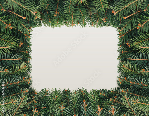 2022. Xmas rectangular frame made of fir Christmas tree branches isolated on pastel beige background. Minimal flat lay. Evergreen natural winter New Year texture. Greeting card concept.