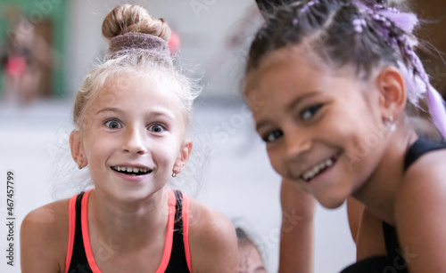 Portrait of funny girls gymnast smiling and making faces in gym on training