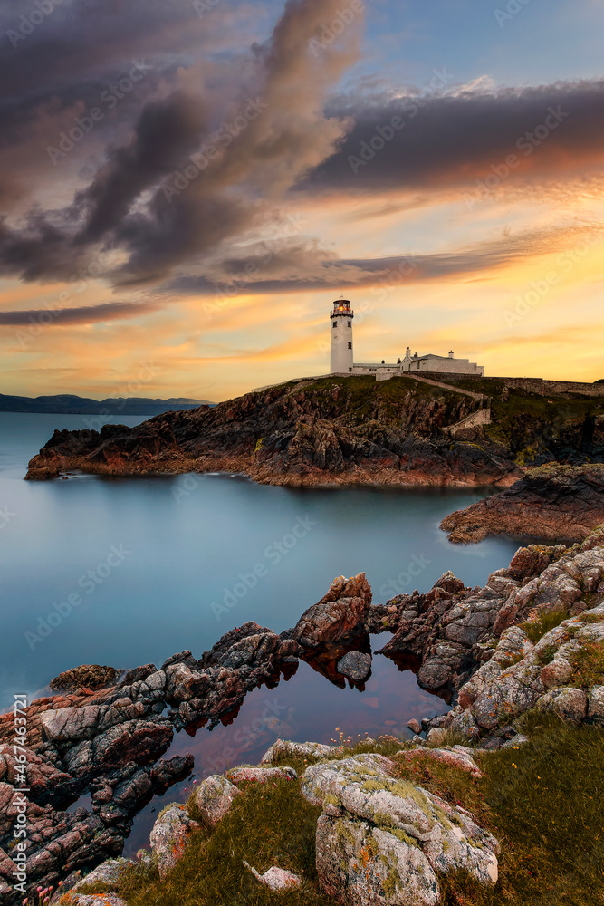 One of the most beautiful lighthouses, Fanad Head lighthouse, Ireland Donegal, Fanad head at Donegal, Ireland with lighthouse at sunset. Colorful sky, mountains and sea One of the most beautiful lighthouses, Fanad Head lighthouse, Ireland Donegal, Fanad head at Donegal, Ireland with lighthouse at sunset. Colorful sky, mountains and sea