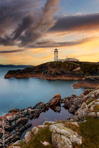 One of the most beautiful lighthouses, Fanad Head lighthouse, Ireland Donegal, Fanad head at Donegal, Ireland with lighthouse at sunset. Colorful sky, mountains and sea 