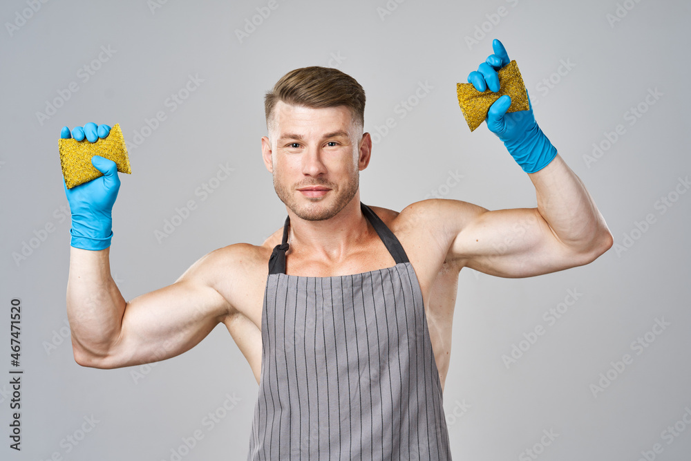 a man in an apron wearing rubber gloves washing dishes