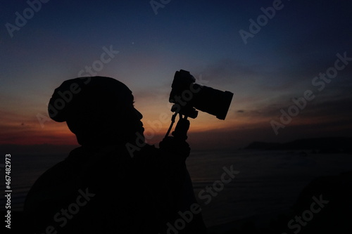 silhouette of a person holding a camera