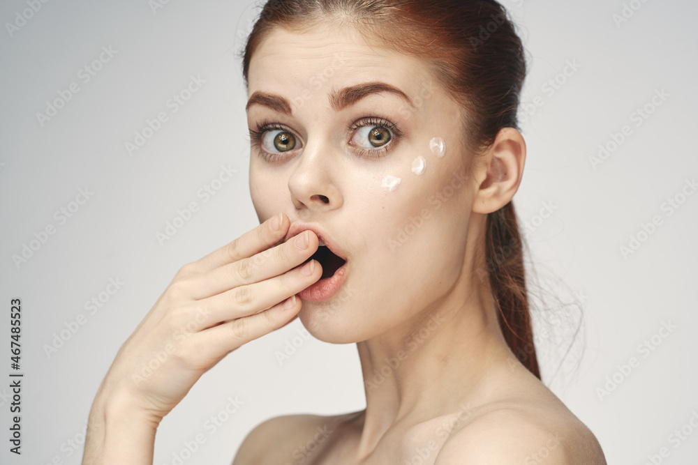 woman with bare shoulders face cream skin care close-up woman with bare shoulders face cream skin care close-up