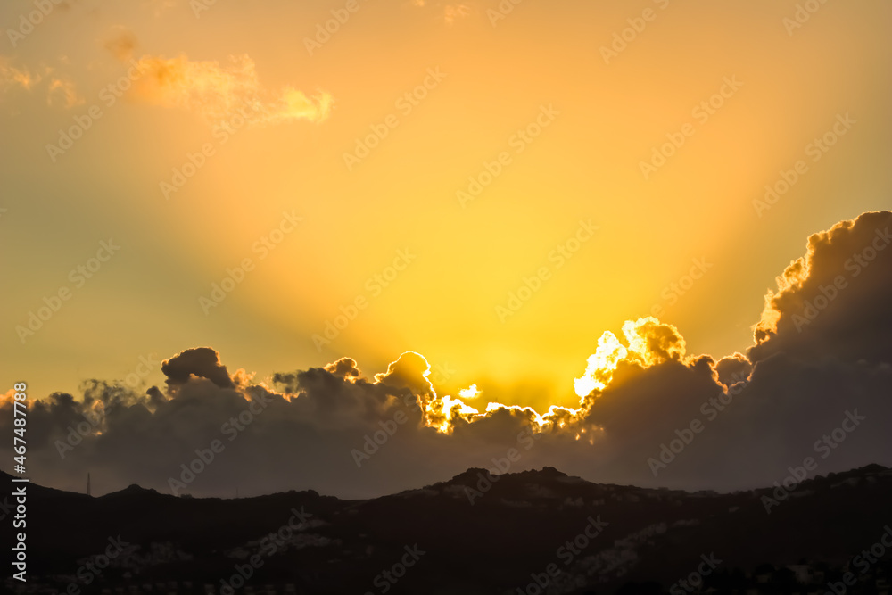 Background from a beautiful sunset with clouds and sunlights over mountanous coast. High quality photo