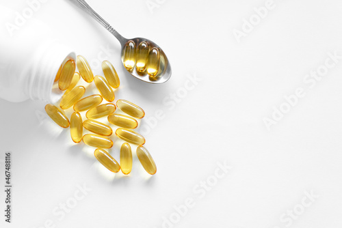 Oliecapsules (zachte capsules) of voedingssupplementen: visolie, omega-3, omega-6, omega-9, vitamine A, vitamine D3, vitamine E, teunisbloemolie, bernagiezaadolie. Gele zachte capsules op een witte ac
