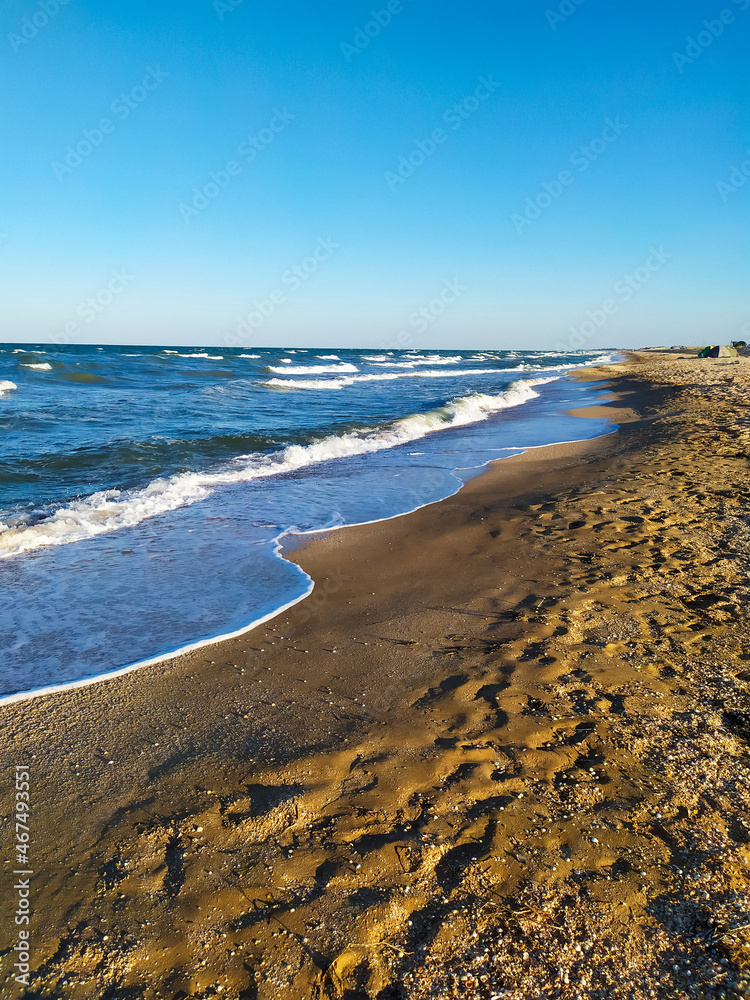 beautiful sea at sunset in summer, clear water, sand beach. silent waves are illuminated by the morning sun. seascape in the evening.