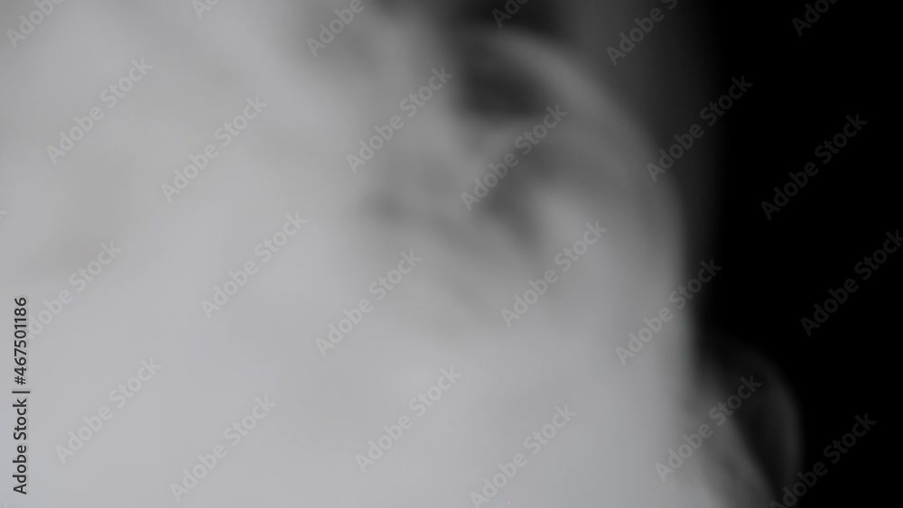 White smoke slowly floating through black background White smoke slowly floating through black background
