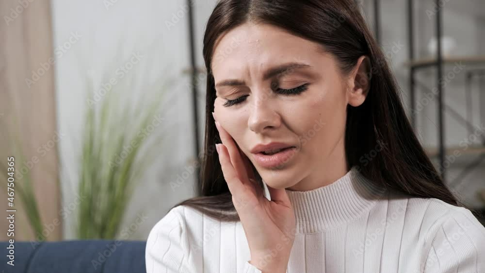 Toothache. Close-up female face upset beautiful brunette woman touch cheek, suffers from toothache, girl having terrible sudden tooth pain at home, need dental treatment. Caries, gum disease concept. Toothache. Close-up female face upset beautiful brunette woman touch cheek, suffers from toothache, girl having terrible sudden tooth pain at home, need dental treatment. Caries, gum disease concept.