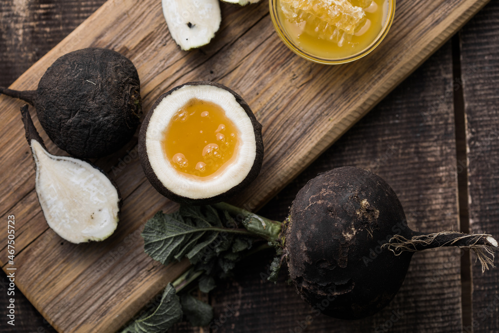 Organic raw Black radish with honey on wooden table. Homemade cough medicine. Folk remedy for immunity. Organic raw Black radish with honey on wooden table. Homemade cough medicine. Folk remedy for immunity.