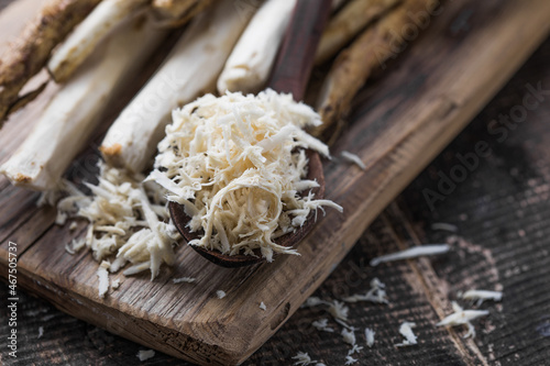 Fresh organic horseradish or Horse-radish root on wooden cutting board.