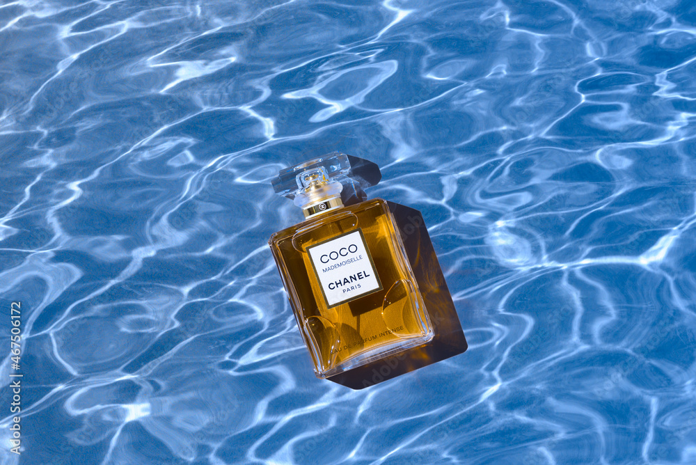A bottle of Chanel perfume on the background of the texture of water, with  a beautiful shadow with highlights. Coco Chanel women's perfume series.  2020-07-05 Samara. Stock Photo