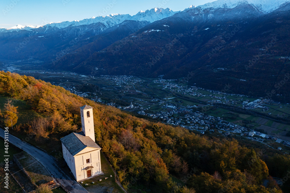 autumn aerial view of the small church of Santa Maria, near Carnale in Valtellina, Italy