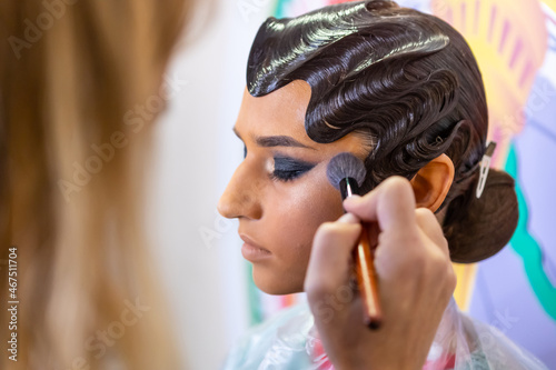 Makeup artist applies blush. Hand of make-up master.  Bright evening makeup.