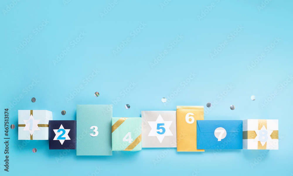 Obraz premium Jewish holiday Hanukkah concept - Gift boxes, stars of David and white candles on blue paper background