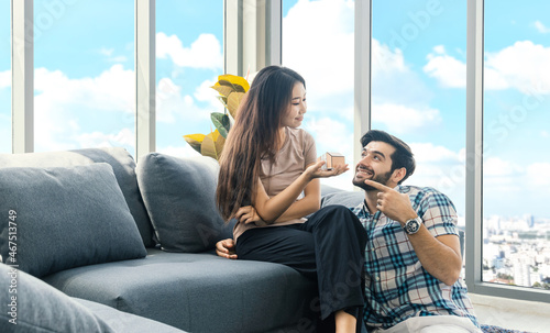 A couple discussing about buying a new home. Female holding model of modern architecture.