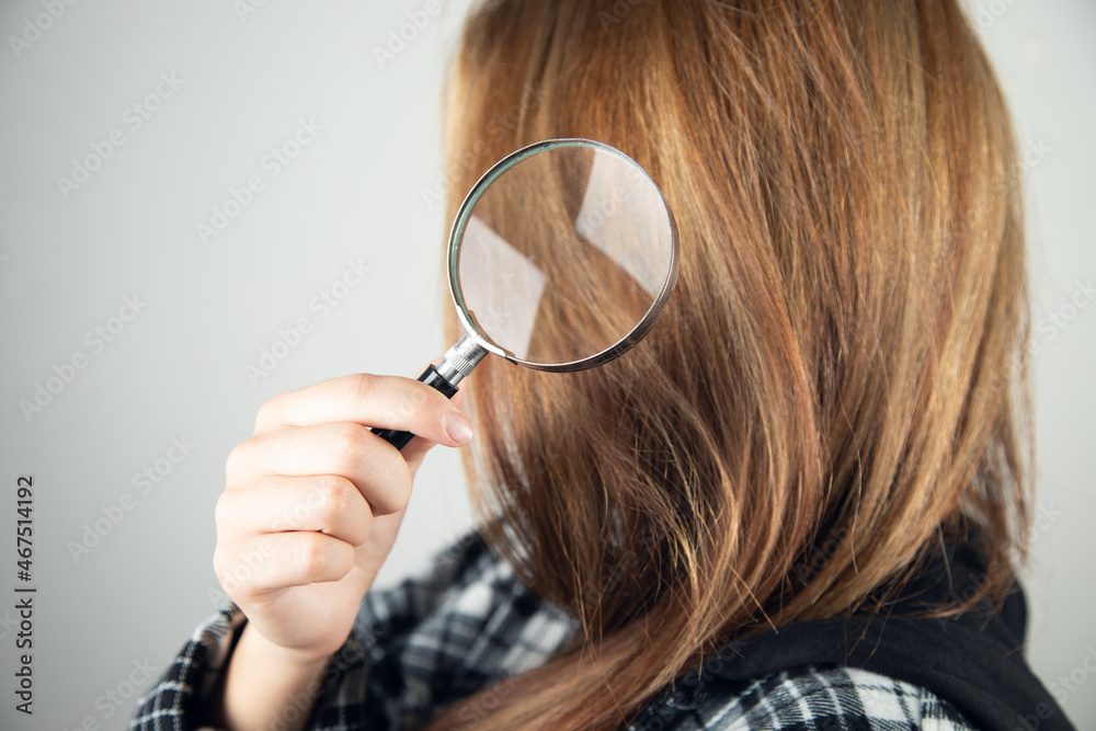 woman holding a magnifying glass in her hair woman holding a magnifying glass in her hair