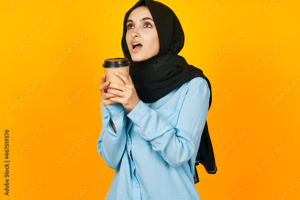 Obraz premium cheerful woman a glass of coffee a warming drink yellow background