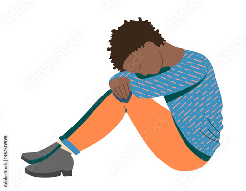 Young African-American girl, a teenager suffering from psychological illnesses, depression, anxiety , is sitting on the floor with her head on her knees