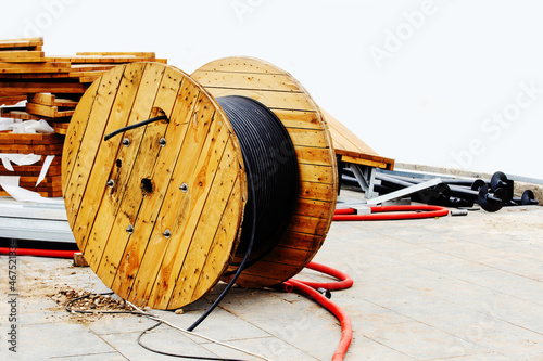 Large wooden reel with industrial power cable. Construction of power lines. Close-up. Copy space