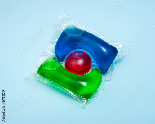 Liquid powder in gel capsule for washing multicolor on blue background