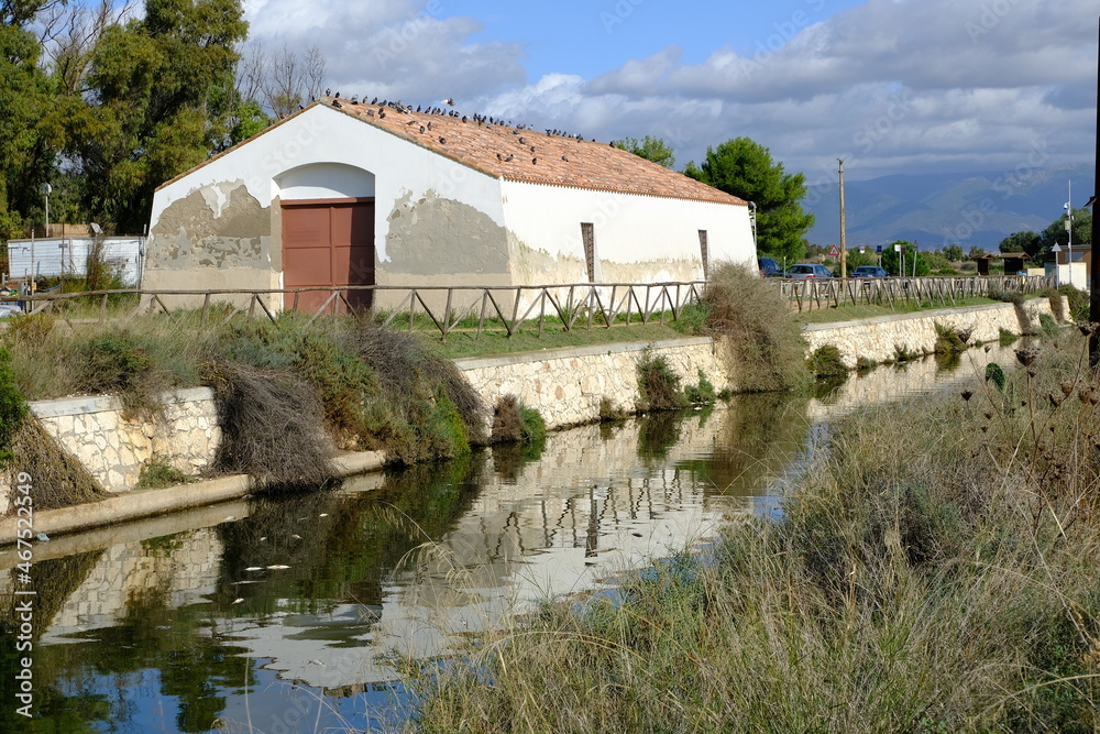Farmhouse. Farmhouse near the canal in the Cagliari lagoon.Wetland with canal. Roof with coppo tiles. Cagliari, Sardinia,  Italy.