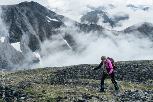 hiker female walking in the mountains. Climbing peak, trekking in Kamchatka