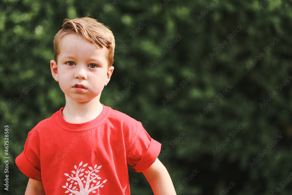 Cute little boy gazing at camera in backyard setting Cute little boy gazing at camera in backyard setting